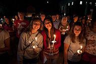 students holding candles at night