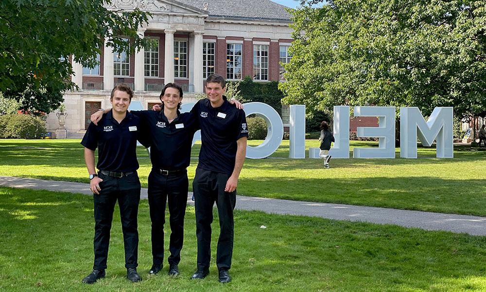 ECM student supervisors celebrate working Commencement in front of the MELIORA letters