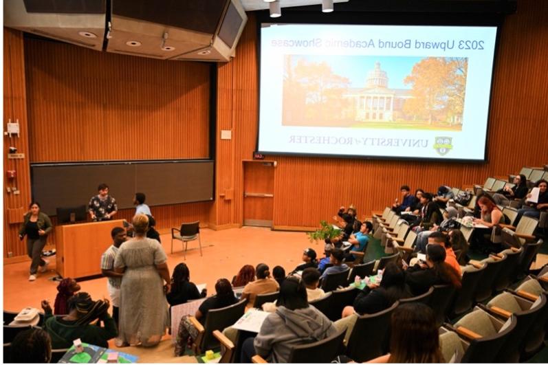 Students watching a presentation in an auditorium.