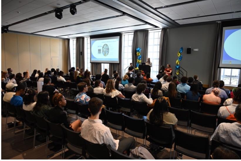 Students in an audience listening to a speaker.